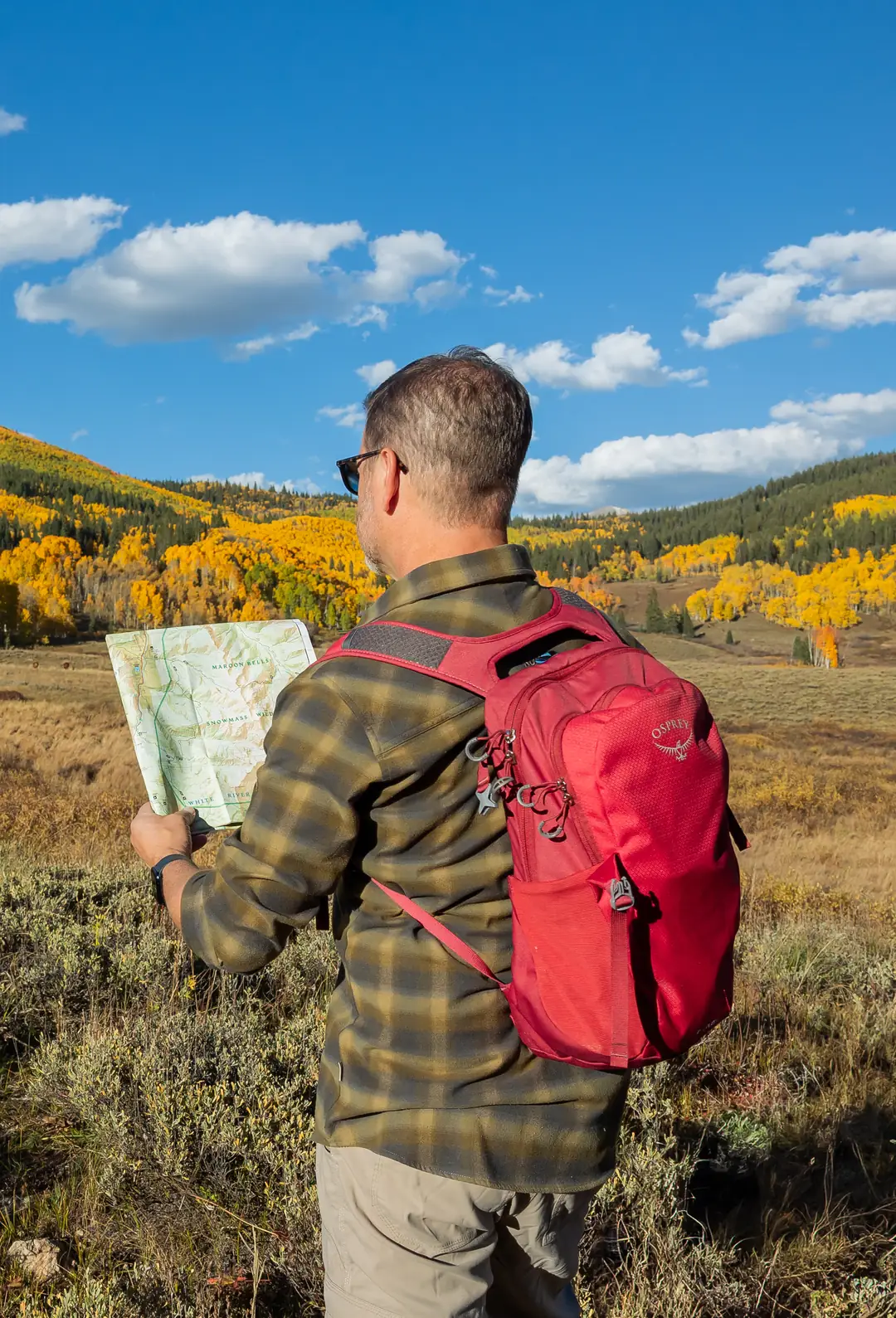 Bill Fournet reading a trail map in an autumn mountain valley