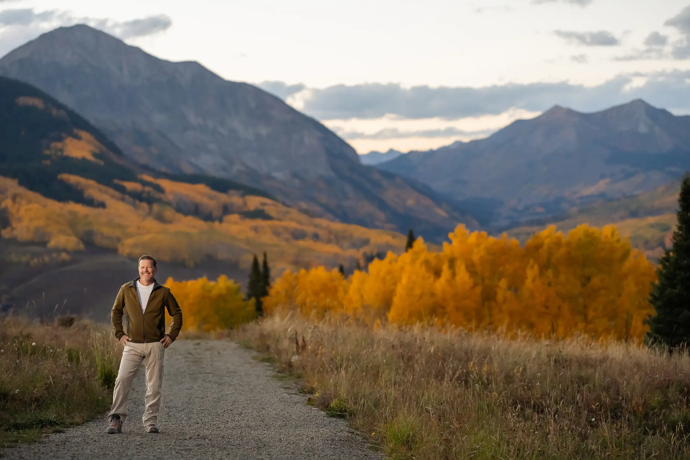 Bill Fournet standing on a mountain trail lined with golden aspens