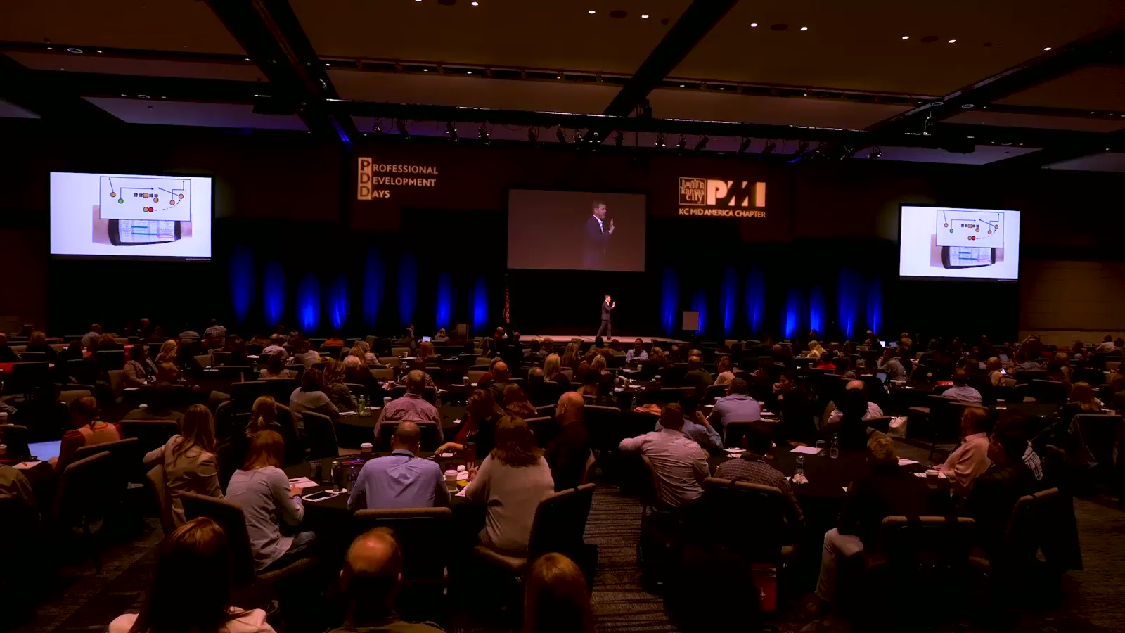 A packed ballroom watching Bill Fournet on stage at PMI Professional Development Days