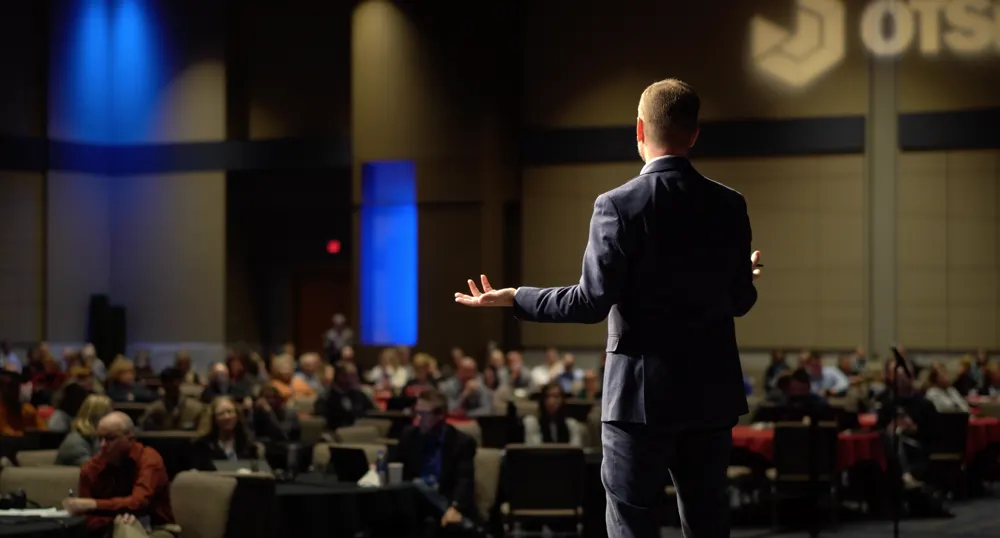 Bill Fournet, seen from behind, addressing a conference audience