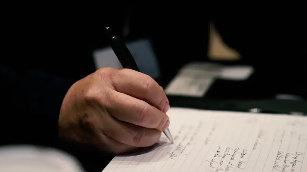 An attendee taking handwritten notes
