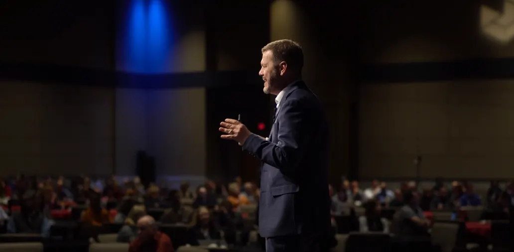 Bill Fournet smiling mid-talk on stage